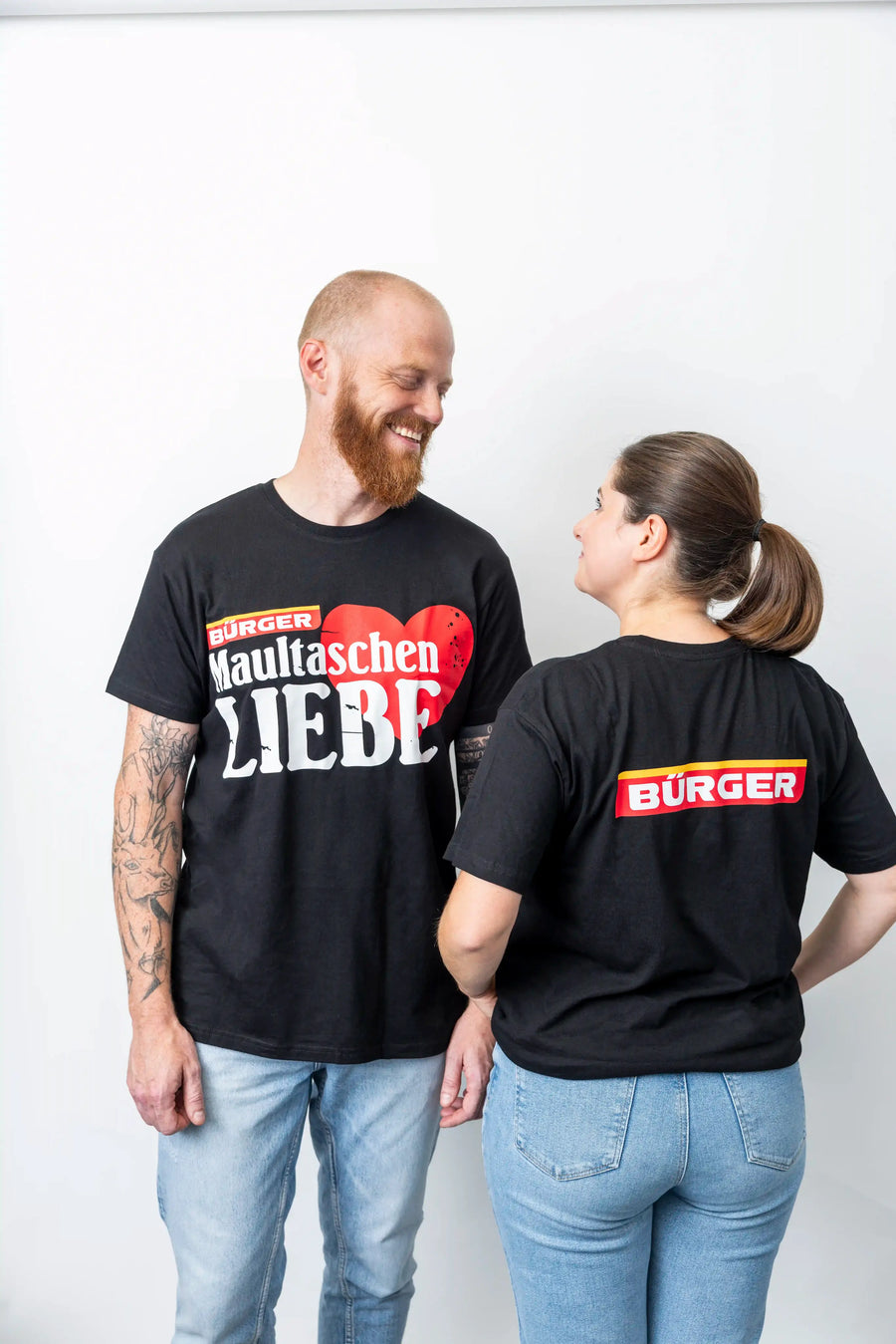 Zwei Personen im Partnerlook mit BÜRGER-T-Shirts, vorne mit Aufdruck „Maultaschen Liebe“.