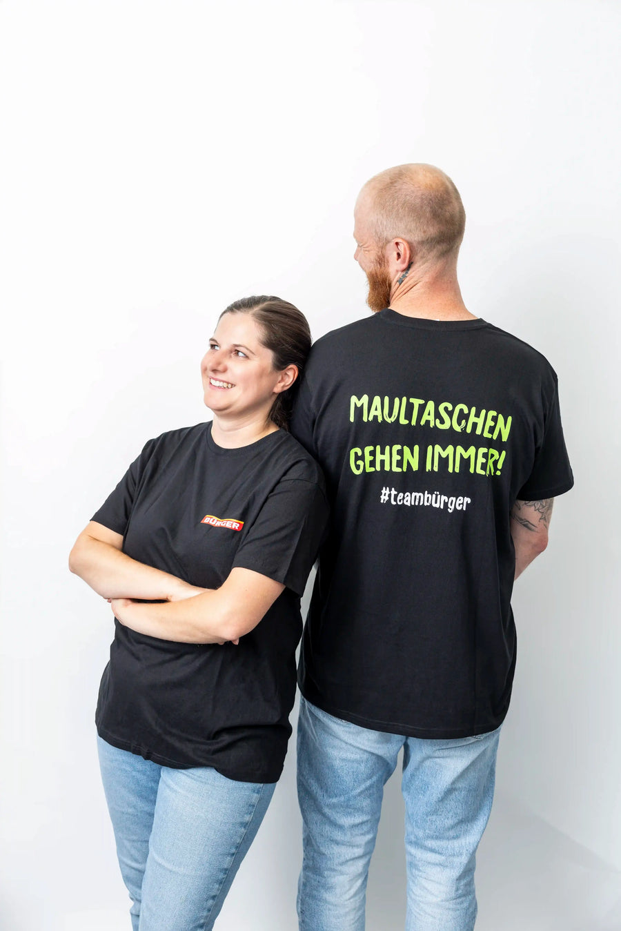 Zwei Personen im BÜRGER-Merchandise, der Rückendruck des Shirts zeigt „Maultaschen gehen immer!“.