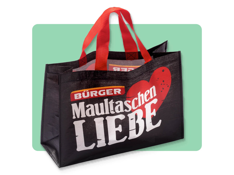 Schwarze BÜRGER-Einkaufstasche mit rotem Henkel und großem Aufdruck „Maultaschenliebe“