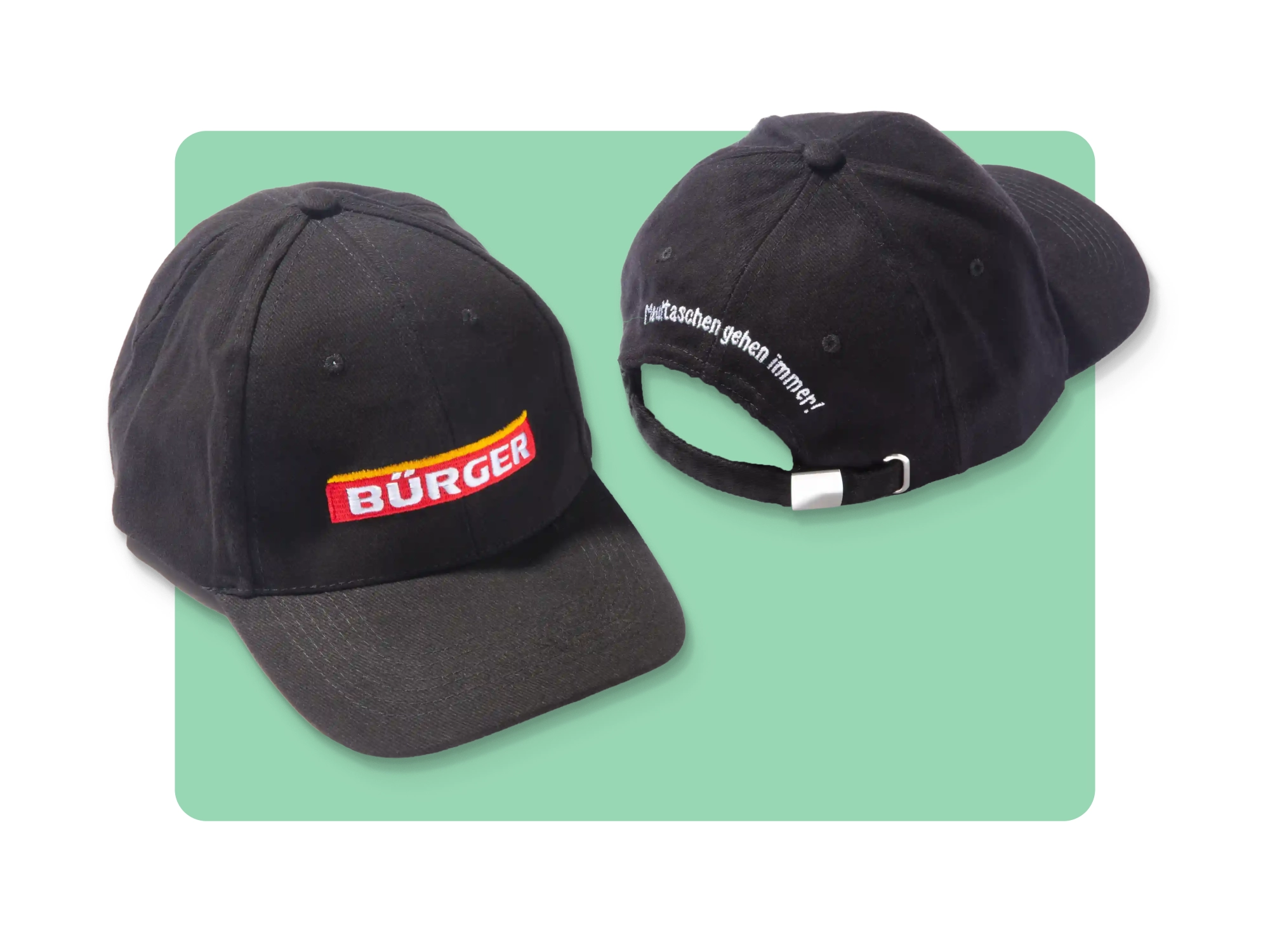 Zwei schwarze BÜRGER-Caps mit Logo vorn und Stick „Maultaschen gehen immer!“ hinten.
