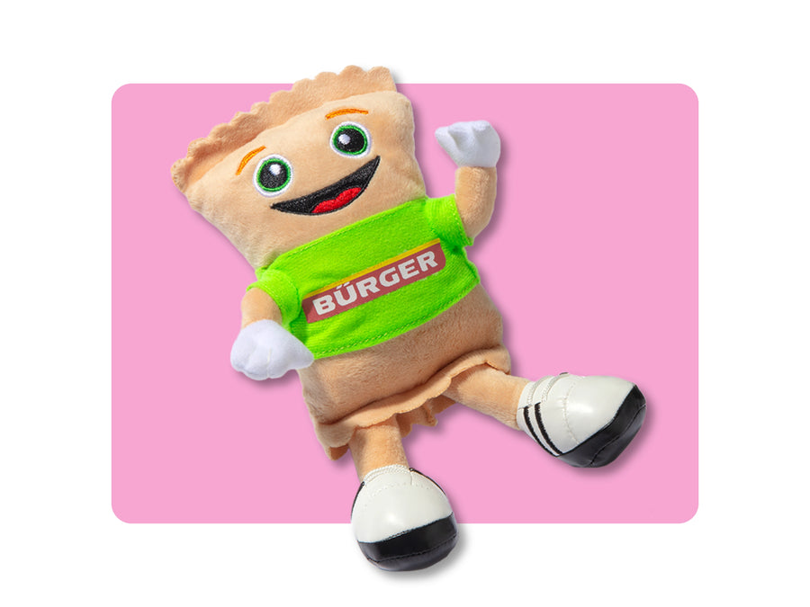 Lächelndes Plüschtier in Maultaschenform mit grünem „BÜRGER“-Shirt und Sportschuhen
