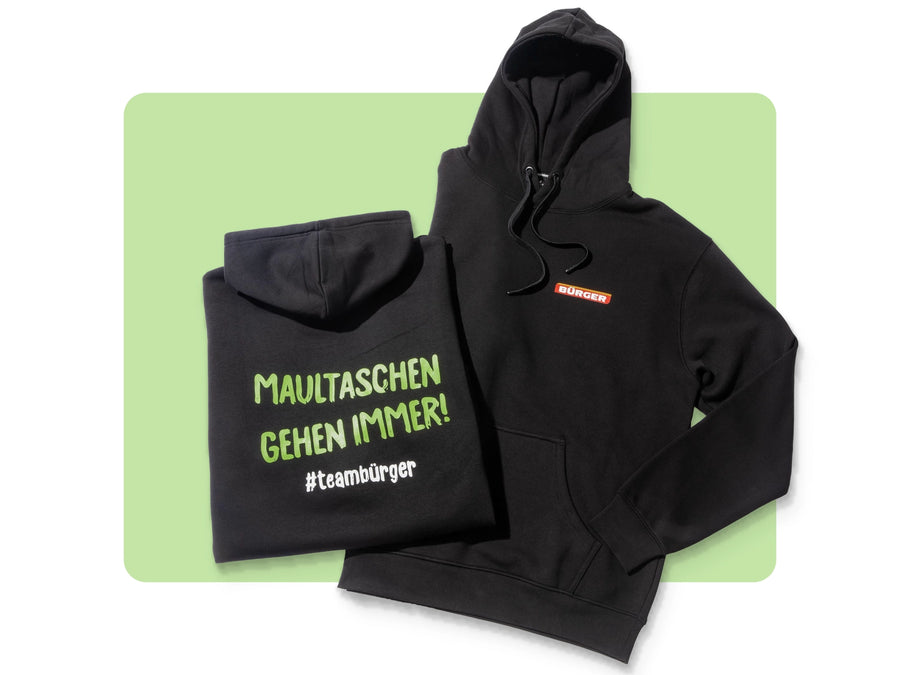 Zwei schwarze BÜRGER-Hoodies, einer mit Logo vorn, einer mit Rückendruck „Maultaschen gehen immer!“