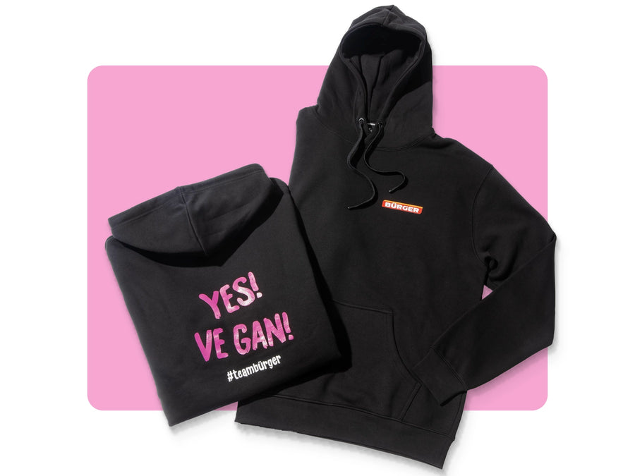 Zwei schwarze BÜRGER-Hoodies, einer mit Logo vorn, einer mit Rückendruck „Yes Ve Gan!“