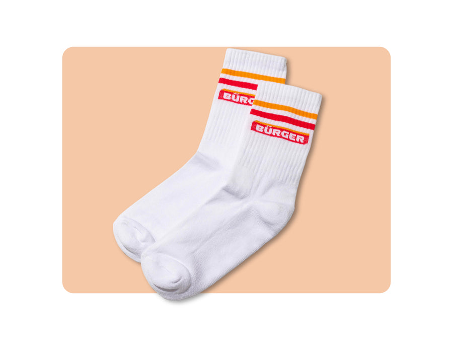 Weiße Sportsocken mit rot-gelben Streifen und „BÜRGER“-Schriftzug, einmal verpackt, einmal lose.